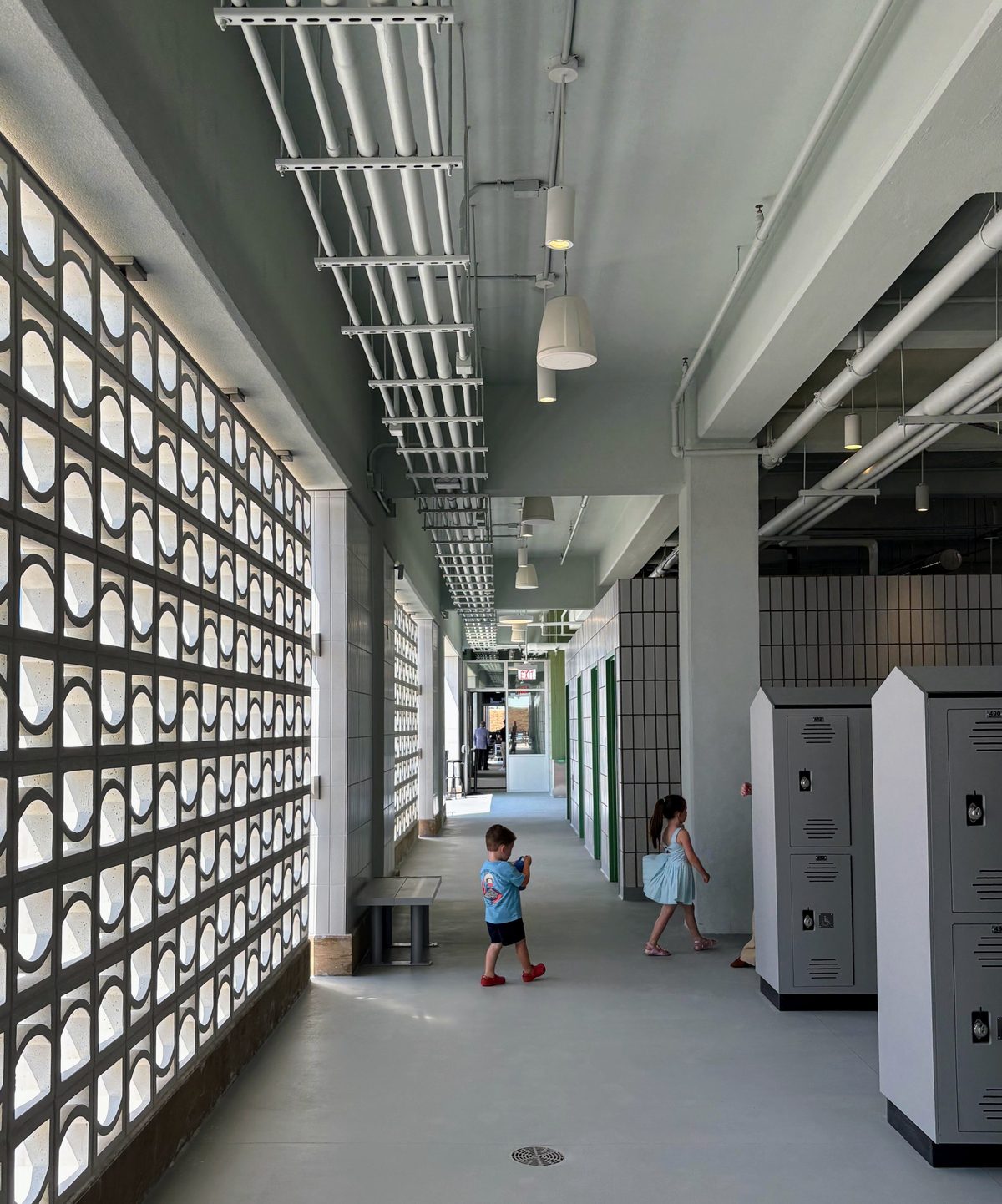 A precast concrete screen wall filters sunlight and allows breezes to pass through the corridor.